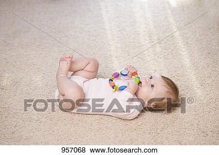 Stock Photo - A baby biting a teething ring. Fotosearch