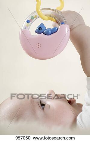 Stock Image - A baby reaching up to touch a mobile. Fotosearch