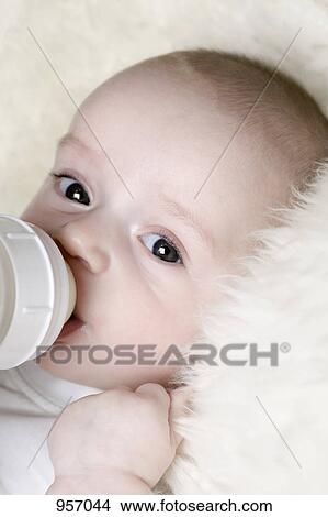 A baby sucking on a baby bottle View Large Photo Image Picture - A baby sucking on a baby bottle. Fotosearch
