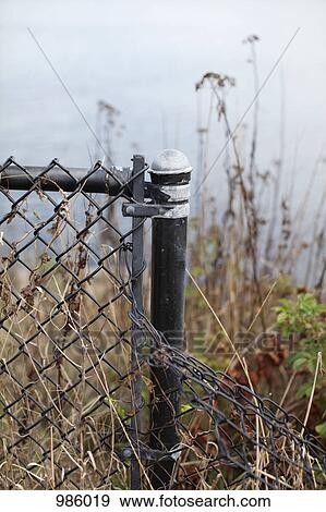 A bent chain-link fence View Large Photo Image Stock Photo - A bent chain-link fence. Fotosearch