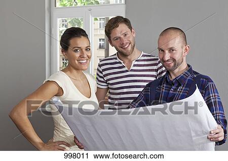 A building contractor showing blueprints to a young couple View Large Photo Image Stock Image - A building contractor showing blueprints to a young couple. Fotosearch