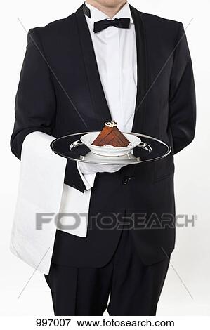 A butler holding a slice of a cake on a silver tray, midsection View Large Photo Image Stock Photo - A butler holding a slice of a cake on a silver tray, midsection. Fotosearch