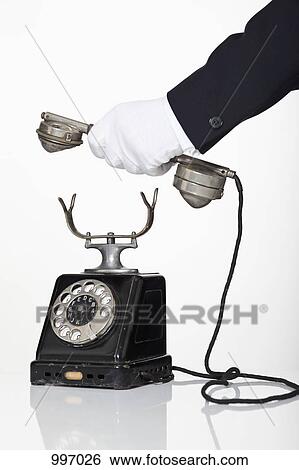 A butler holding the receiver of a rotary phone, focus on hand View Large Photo Image Stock Photograph - A butler holding the receiver of a rotary phone, focus on hand. Fotosearch