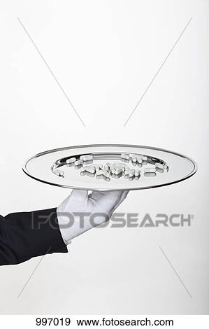 A butler presenting a large amount of pills on a silver tray, focus on hand View Large Photo Image Stock Photo - A butler presenting a large amount of pills on a silver tray, focus on hand. Fotosearch