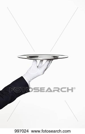 A butler presenting an empty silver tray, focus on hand View Large Photo Image Picture - A butler presenting an empty silver tray, focus on hand. Fotosearch