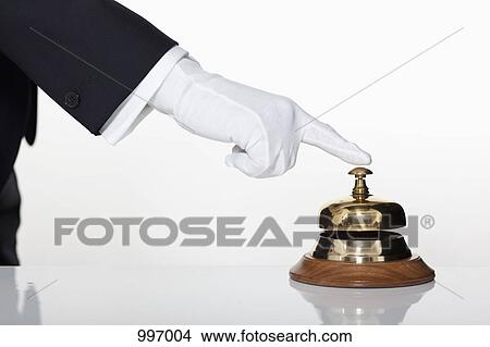 Picture - A butler pressing a service bell, focus on hand. Fotosearch