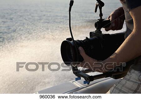 A cameraman filming on a motorboat View Large Photo Image Stock Photograph - A cameraman filming on a motorboat. Fotosearch