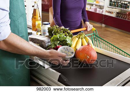 A cashier and customer at the checkout line of a supermarket, midsection View Large Photo Image Stock Image - A cashier and customer at the checkout line of a supermarket, midsection. Fotosearch