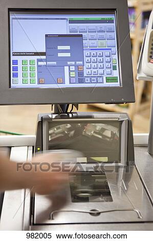 Stock Photography - A cashier scanning groceries at a supermarket, focus on hand. Fotosearch