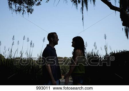 A couple chatting outdoors in summer, back lit View Large Photo Image Stock Image - A couple chatting outdoors in summer, back lit. Fotosearch