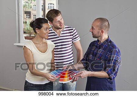 A couple consulting with a house painter, home interior View Large Photo Image Picture - A couple consulting with a house painter, home interior. Fotosearch