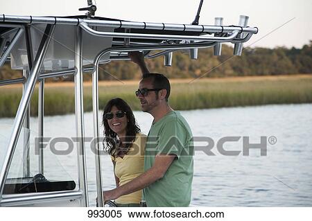 Stock Photography - A couple out on their motorboat. Fotosearch