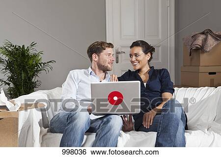Stock Photograph - A couple taking a break from moving. Fotosearch