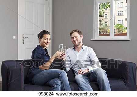 A couple toasting champagne flutes at home View Large Photo Image Picture - A couple toasting champagne flutes at home. Fotosearch