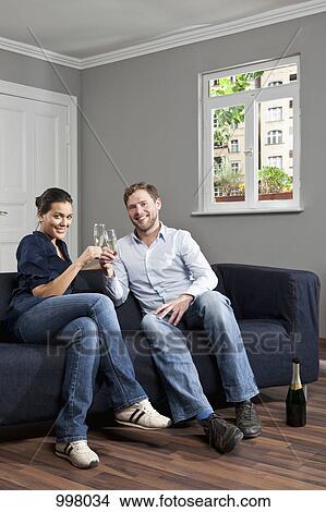 A couple toasting champagne flutes at home View Large Photo Image Picture - A couple toasting champagne flutes at home. Fotosearch