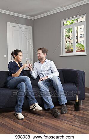 A couple toasting champagne flutes at home View Large Photo Image Stock Photo - A couple toasting champagne flutes at home. Fotosearch