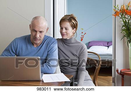 A couple using a laptop together View Large Photo Image Stock Image - A couple using a laptop together. Fotosearch
