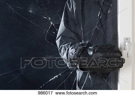 A criminal breaking into a window, focus on hand View Large Photo Image Stock Photo - A criminal breaking into a window, focus on hand. Fotosearch