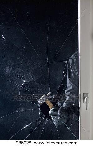 A criminal breaking into a window, focus on hand View Large Photo Image Stock Photography - A criminal breaking into a window, focus on hand. Fotosearch