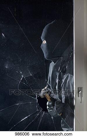 A criminal breaking into a window with a hammer View Large Photo Image Stock Photograph - A criminal breaking into a window with a hammer. Fotosearch