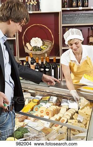 A customer and clerk in a wine and cheese shop View Large Photo Image Picture - A customer and clerk in a wine and cheese shop. Fotosearch