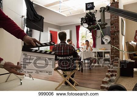 A director on a film set watching actors perform a scene View Large Photo Image Stock Photograph - A director on a film set watching actors perform a scene. Fotosearch