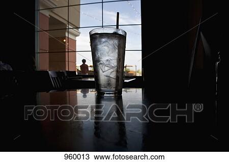 A glass of ice water on a table in a restaurant View Large Photo Image Stock Image - A glass of ice water on a table in a restaurant. Fotosearch