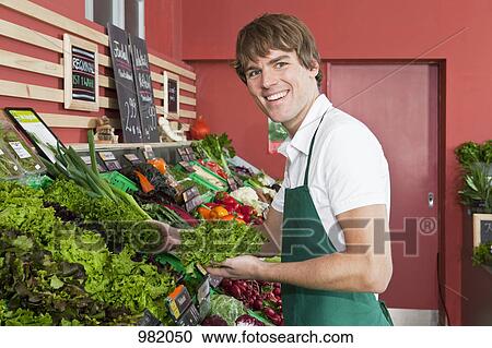 A grocery stocker stocking leaf lettuce View Large Photo Image Stock Image - A grocery stocker stocking leaf lettuce. Fotosearch