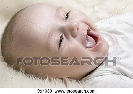 Stock Photo - A happy baby lying on a shag rug. Fotosearch