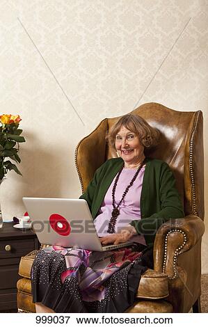 A happy senior woman using a laptop View Large Photo Image Stock Photo - A happy senior woman using a laptop. Fotosearch