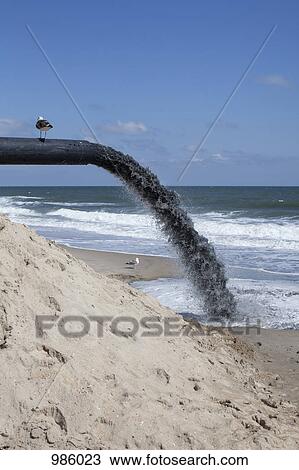 A large pipe pumping sand onto the beach View Large Photo Image Stock Image - A large pipe pumping sand onto the beach. Fotosearch