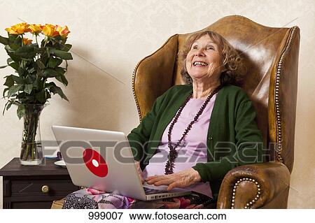 A laughing senior woman using a laptop View Large Photo Image Stock Photo - A laughing senior woman using a laptop. Fotosearch
