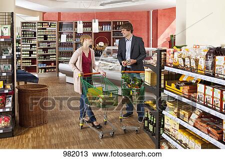 Stock Image - A man and a woman chatting in a supermarket. Fotosearch