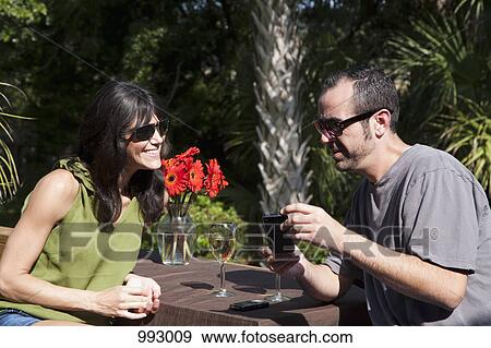 A man and woman looking at a smart phone on a backyard deck View Large Photo Image Stock Photo - A man and woman looking at a smart phone on a backyard deck. Fotosearch