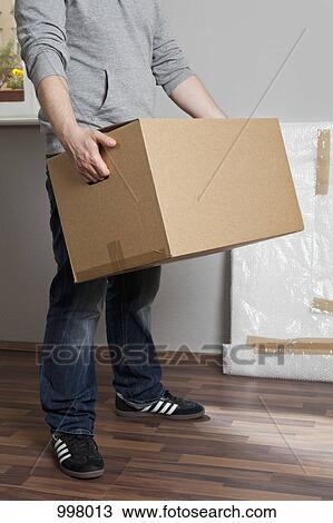 A man carrying a moving box, neck down View Large Photo Image Stock Image - A man carrying a moving box, neck down. Fotosearch