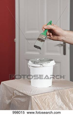 A man dipping a paintbrush into a paint can, focus on hand View Large Photo Image Stock Photography - A man dipping a paintbrush into a paint can, focus on hand. Fotosearch