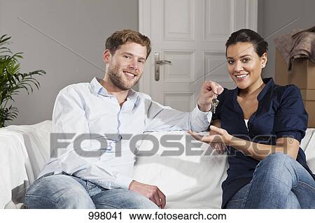 A man giving a woman a set of keys for their new house View Large Photo Image Stock Image - A man giving a woman a set of keys for their new house. Fotosearch