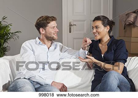 A man giving a woman a set of keys for their new house View Large Photo Image Stock Photo - A man giving a woman a set of keys for their new house. Fotosearch