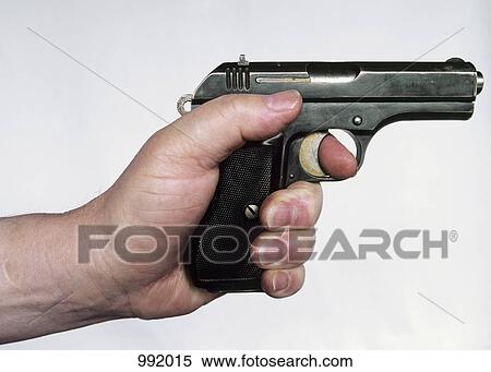 Stock Photography - A man holding a gun, side view, hand only. Fotosearch