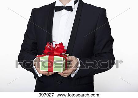 A man in a tuxedo holding a birthday gift, midsection View Large Photo Image Stock Photo - A man in a tuxedo holding a birthday gift, midsection. Fotosearch