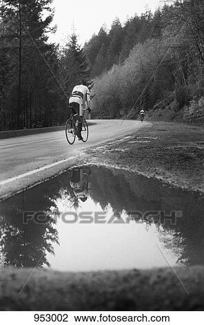 A man on a racing bicycle cycling up a mountain road View Large Photo Image Stock Image - A man on a racing bicycle cycling up a mountain road. Fotosearch