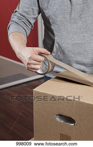 A man taping a moving box shut, midsection View Large Photo Image Stock Photo - A man taping a moving box shut, midsection. Fotosearch