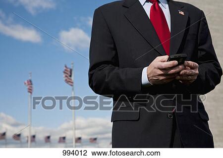 A man text messaging, American flags in the background View Large Photo Image Stock Image - A man text messaging, American flags in the background. Fotosearch
