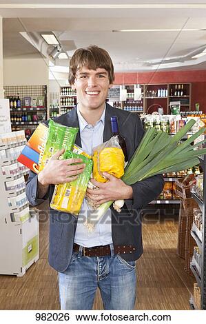 A man with an armful of groceries View Large Photo Image Stock Photograph - A man with an armful of groceries. Fotosearch