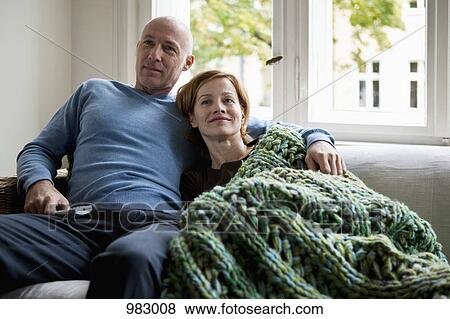 A mature couple relaxing on a sofa View Large Photo Image Stock Photo - A mature couple relaxing on a sofa. Fotosearch