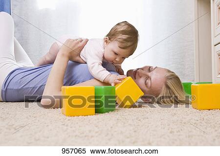 Stock Photography - A mother and baby daughter playing with toy blocks. Fotosearch