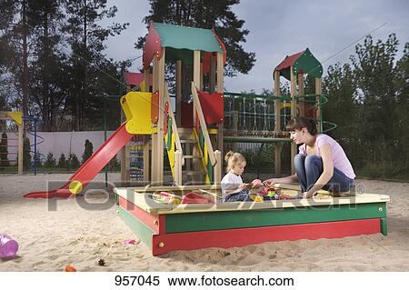 A mother and daughter playing in a sandbox View Large Photo Image Stock Photography - A mother and daughter playing in a sandbox. Fotosearch