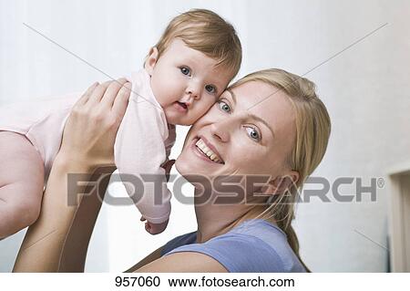 A mother holding her baby daughter View Large Photo Image Stock Image - A mother holding her baby daughter. Fotosearch