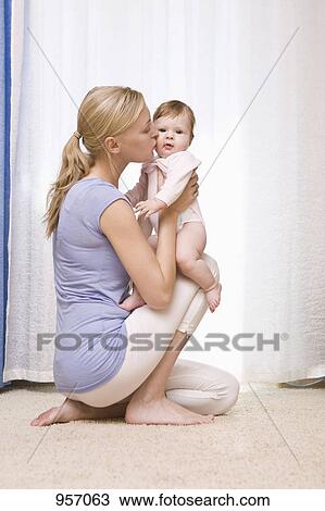 A mother kissing her baby daughter View Large Photo Image Stock Image - A mother kissing her baby daughter. Fotosearch