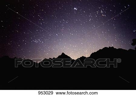 A mountain silhouetted against a night sky filled with stars View Large Photo Image Stock Photo - A mountain silhouetted against a night sky filled with stars. Fotosearch